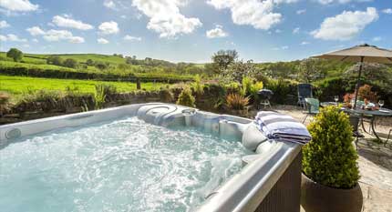 Un grand bain à remous dans un beau jardin avec beaucoup de jets, d'un de nos chalets de vacances avec bains à remous au Royaume-Uni.